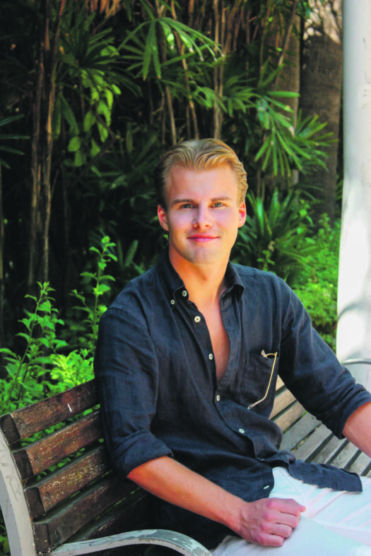 Kuvassa Matias Lehto istuu puiston penkillä